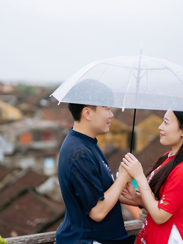 A couple sharing one umbrella on a rainy monsoon night